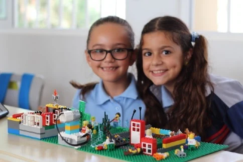Two children sharing their LEGO creation at a workshop
